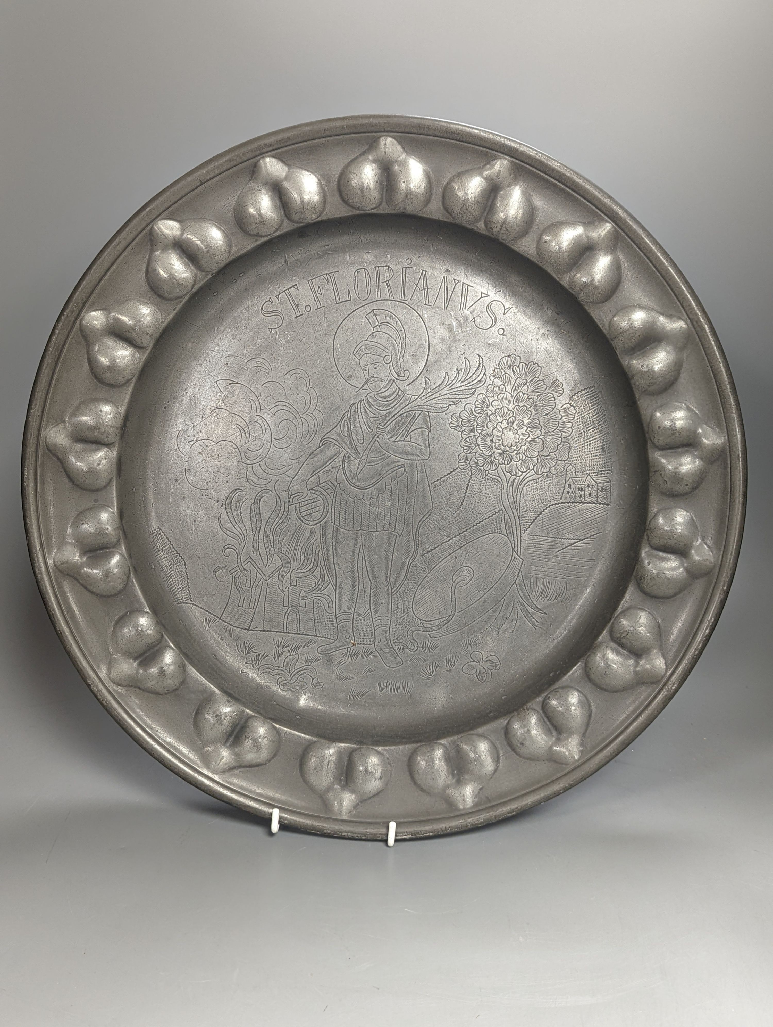 A near pair of Salzburg pewter wrigglework chargers, diameter 41cm, and six similar plates, 18th/19th century